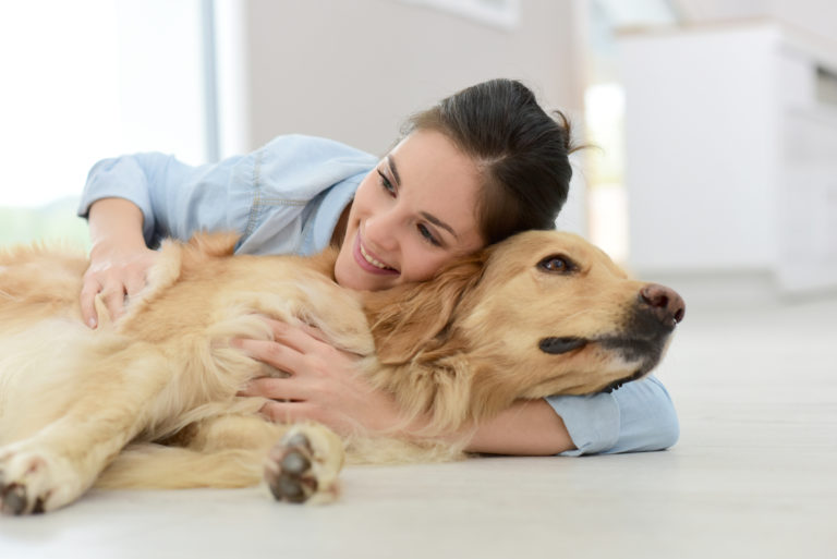 Frau knuddelt Golden Retriever